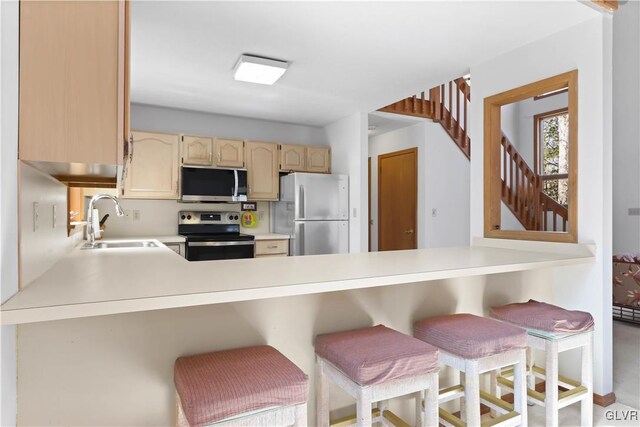 367 Saunders Dr, Lehman Twp, PA 18324 - kitchen featuring light countertops, a peninsula, stainless steel appliances, a sink, and a breakfast bar area