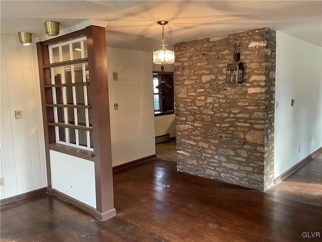 interior space with baseboards, a baseboard heating unit, and hardwood / wood-style flooring