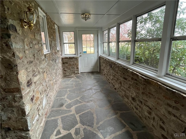 unfurnished sunroom with stone flooring