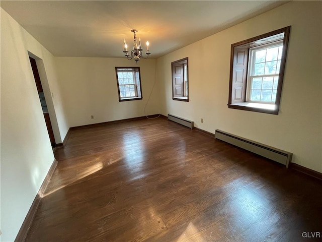 empty room with baseboards, baseboard heating, a chandelier, and dark wood-style floors