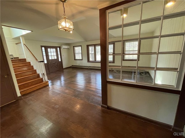 entryway with wood finished floors, stairway, vaulted ceiling, a wall mounted AC, and baseboard heating