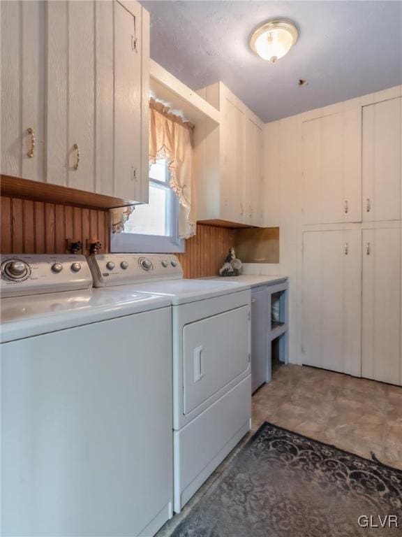 laundry area featuring washing machine and dryer, cabinet space, and light floors
