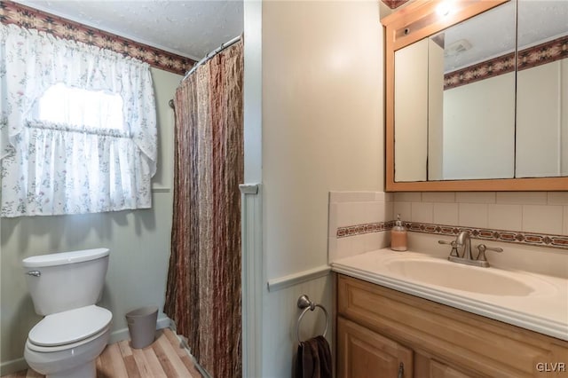 full bath with toilet, vanity, backsplash, a shower with curtain, and wood finished floors