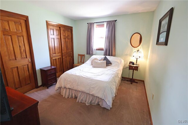 bedroom with light carpet, a closet, and baseboards