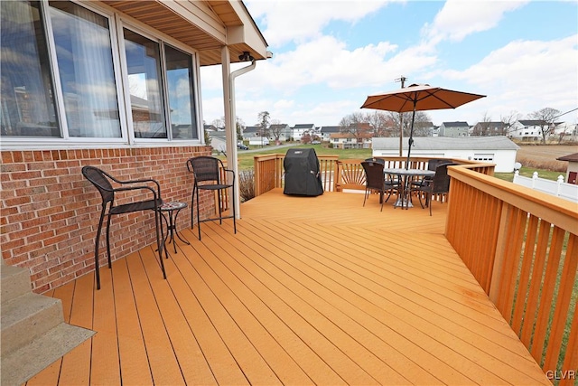 wooden deck with a residential view and outdoor dining area