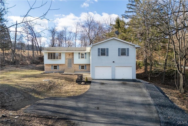 split foyer home featuring an attached garage and driveway