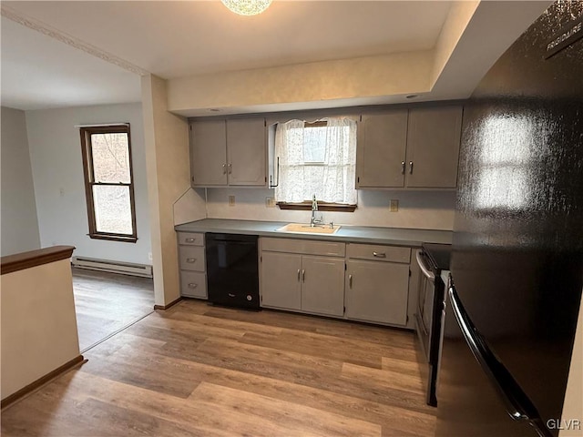 kitchen featuring baseboard heating, gray cabinets, light wood-style flooring, black appliances, and a sink