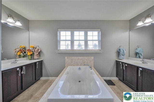 full bathroom featuring a sink, two vanities, and a garden tub