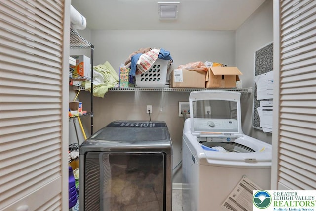 laundry room featuring separate washer and dryer and visible vents