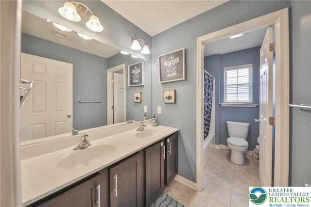 full bathroom with a sink, tile patterned floors, toilet, and double vanity