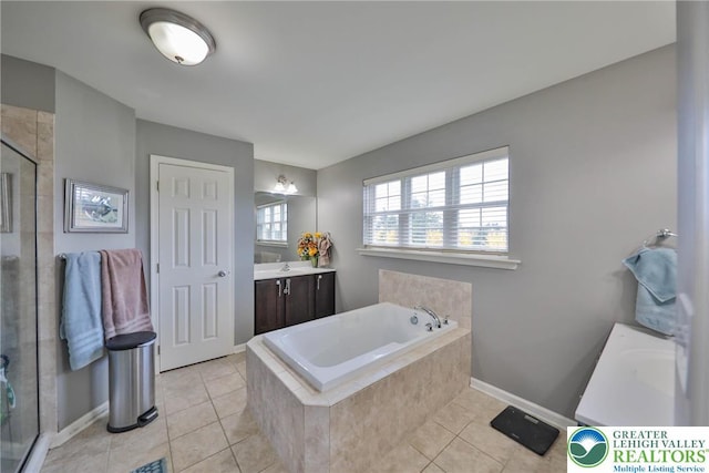 full bath featuring a bath, vanity, tile patterned flooring, a stall shower, and baseboards