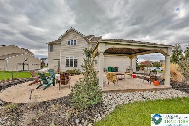 rear view of property featuring an outdoor fire pit, a gazebo, a patio area, and fence