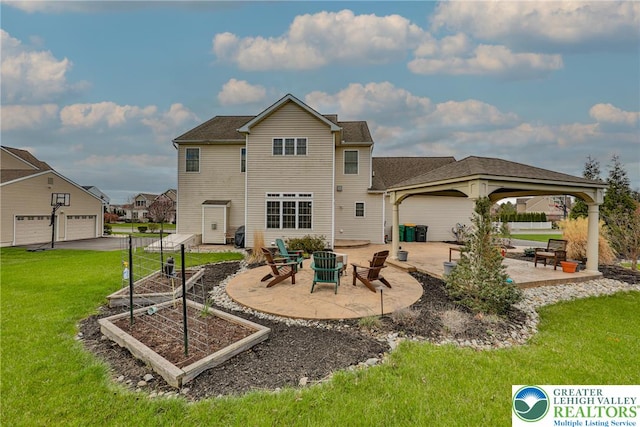 back of house featuring an outdoor fire pit, a vegetable garden, a gazebo, a lawn, and a patio