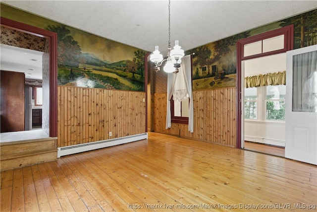 221 Franklin St, Alburtis Borough, PA 18011 - unfurnished dining area with a healthy amount of sunlight, a baseboard heating unit, wood-type flooring, and an inviting chandelier