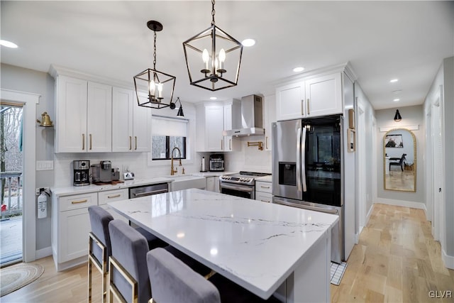 5627 Pembrook Dr, Coolbaugh Twp, PA 18466 - kitchen featuring wall chimney range hood, appliances with stainless steel finishes, white cabinetry, a chandelier, and recessed lighting