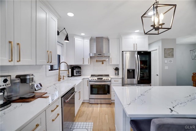 5627 Pembrook Dr, Coolbaugh Twp, PA 18466 - kitchen with stainless steel appliances, wall chimney exhaust hood, white cabinets, tasteful backsplash, and recessed lighting