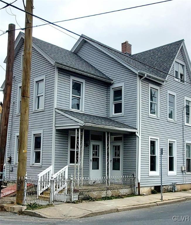 view of front of home with a fenced front yard, roof with shingles, and a chimney