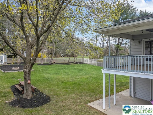 view of yard with an outdoor structure, a fenced backyard, and a patio area