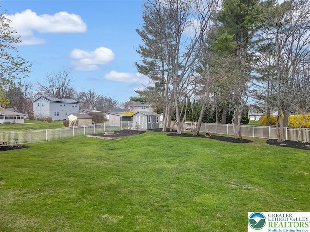 view of yard featuring a fenced backyard, a shed, and an outdoor structure