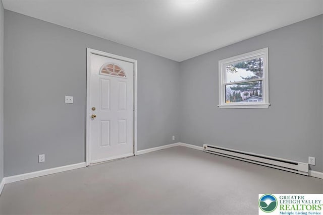unfurnished room with a baseboard heating unit and baseboards