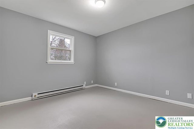 empty room featuring concrete flooring, baseboards, and a baseboard heating unit