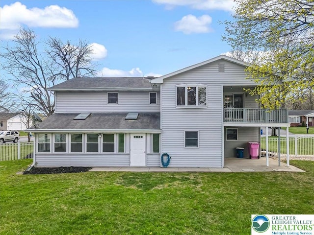 rear view of property with a shingled roof, fence, a patio, and a lawn