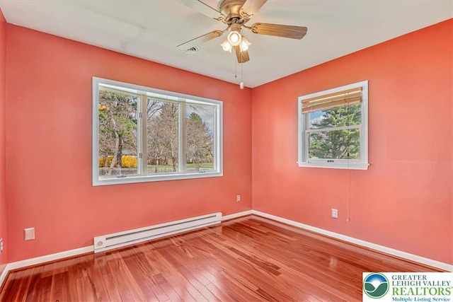 empty room featuring wood-type flooring, baseboards, ceiling fan, and baseboard heating