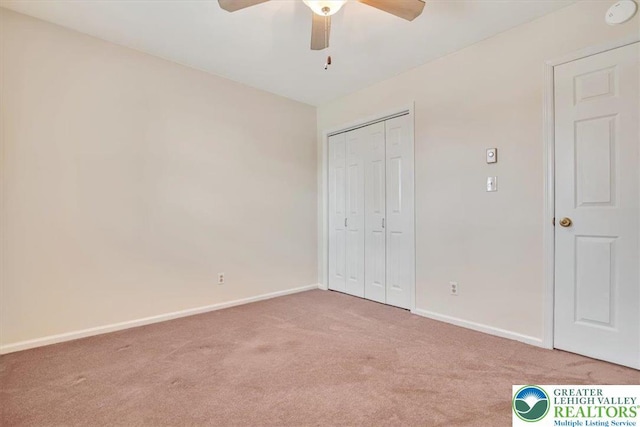 unfurnished bedroom featuring a closet, baseboards, a ceiling fan, and carpet floors