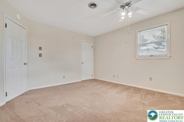 empty room featuring baseboards, a ceiling fan, visible vents, and carpet floors