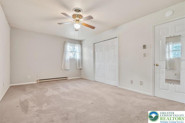 unfurnished bedroom with a baseboard radiator, a closet, carpet flooring, and baseboards