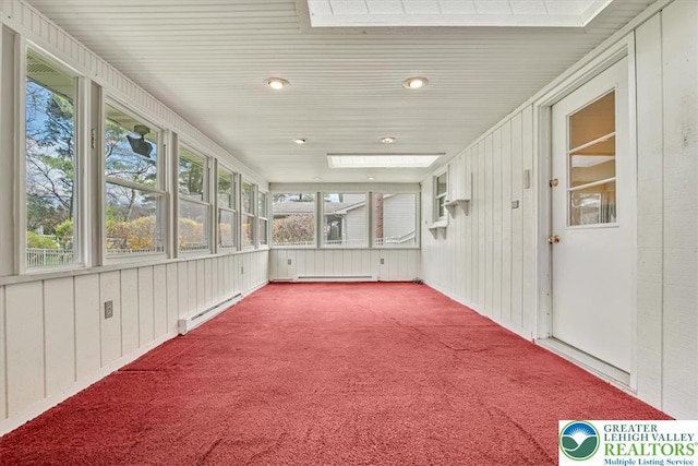 unfurnished sunroom with a wealth of natural light and baseboard heating
