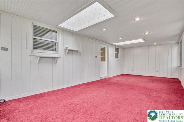 unfurnished room with wood walls, recessed lighting, and carpet