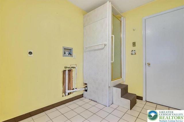 clothes washing area featuring baseboards, laundry area, electric dryer hookup, hookup for a washing machine, and light tile patterned flooring