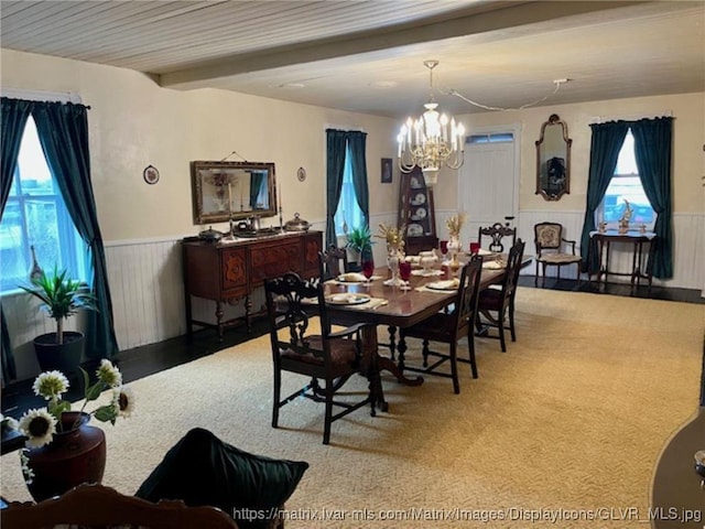 dining space featuring a wainscoted wall and a chandelier