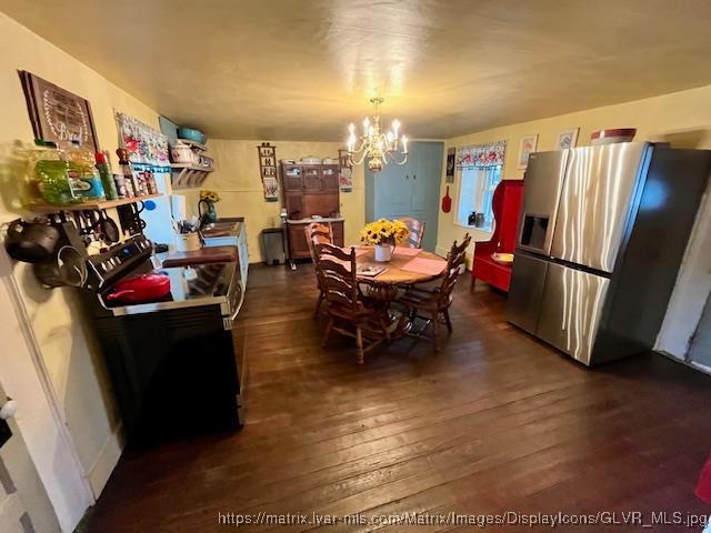 dining space with dark wood-type flooring and a notable chandelier