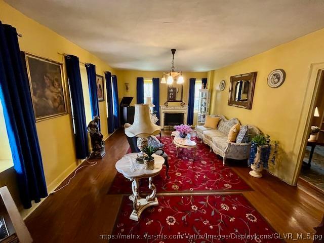 living room featuring baseboards, wood finished floors, and a fireplace