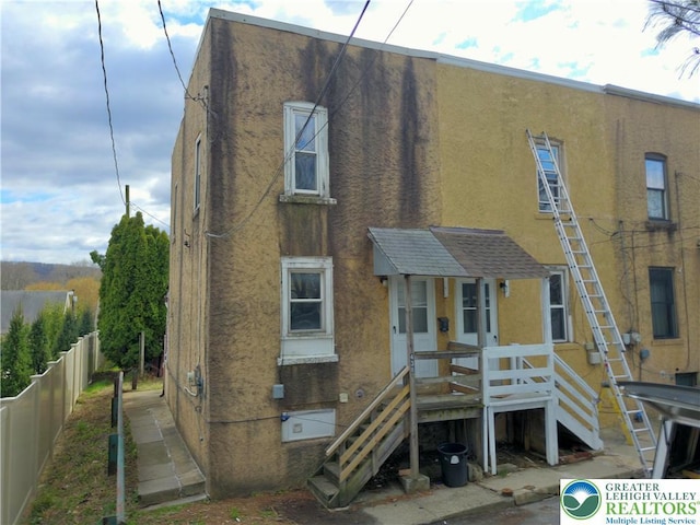 view of front facade featuring fence and stucco siding