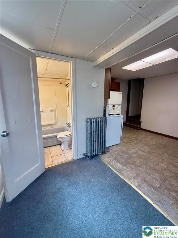 interior space featuring washer / clothes dryer and radiator heating unit
