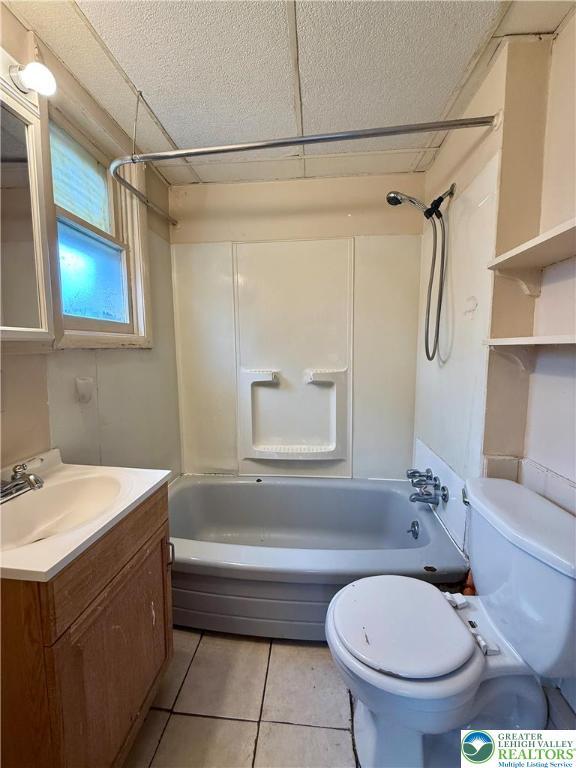 full bath featuring tile patterned floors, toilet, vanity, and bathing tub / shower combination