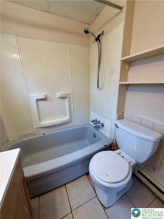 full bath with toilet, tile patterned floors, a baseboard heating unit, and shower / bathing tub combination
