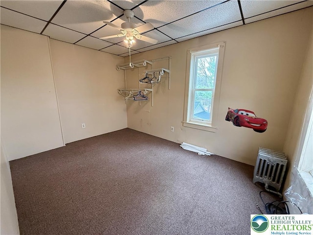 carpeted spare room with a paneled ceiling and a ceiling fan