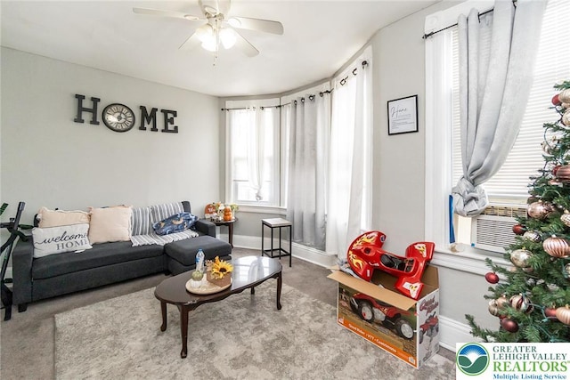 living area with carpet floors, baseboards, a ceiling fan, and cooling unit