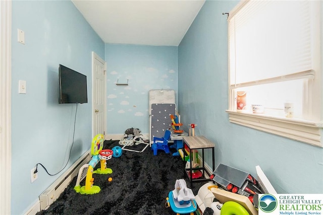 playroom featuring a baseboard radiator, baseboards, and carpet
