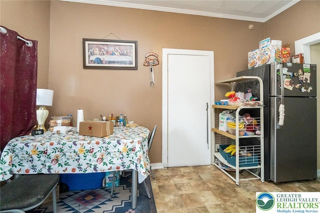 dining room featuring crown molding and baseboards