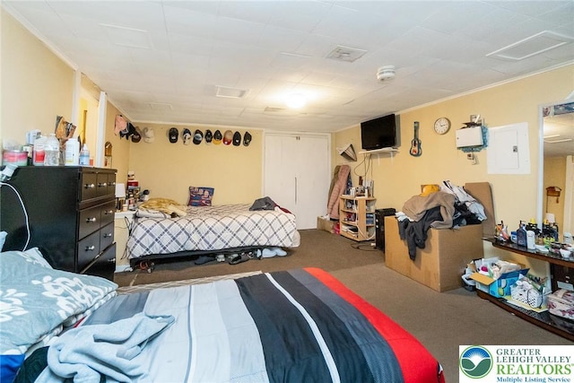 bedroom with ornamental molding, electric panel, and carpet floors