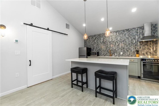 5112 Creek Rd, Heidelberg Twp, PA 18078 - kitchen with wall chimney range hood, a barn door, visible vents, and appliances with stainless steel finishes