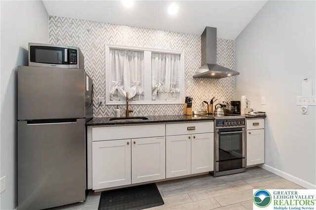 5112 Creek Rd, Heidelberg Twp, PA 18078 - kitchen featuring wall chimney exhaust hood, white cabinetry, a sink, stainless steel appliances, and decorative backsplash