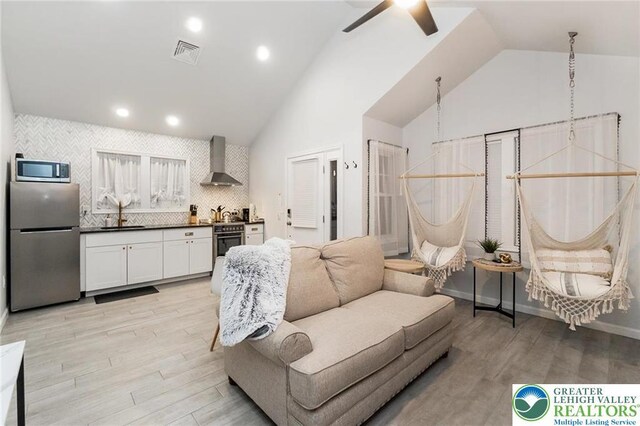 5112 Creek Rd, Heidelberg Twp, PA 18078 - living room featuring light wood-type flooring, ceiling fan, vaulted ceiling, and visible vents