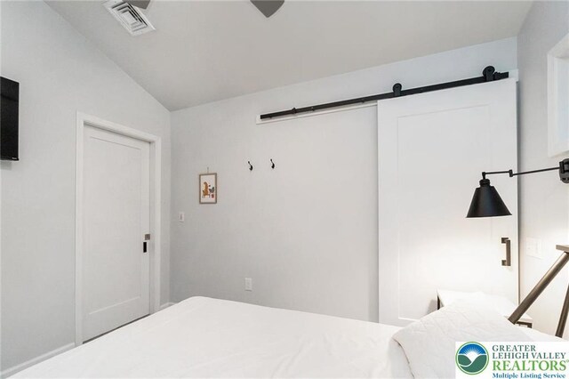 5112 Creek Rd, Heidelberg Twp, PA 18078 - bedroom with a barn door, visible vents, and lofted ceiling