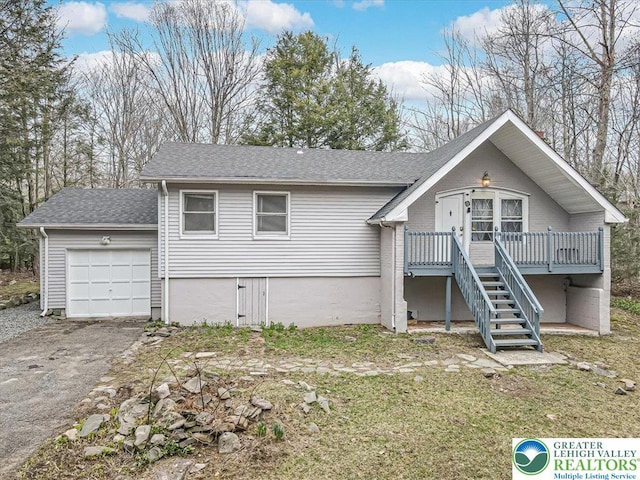 view of front of house with a deck, an attached garage, aphalt driveway, stairs, and roof with shingles